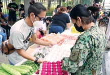PRO-6: No profiling of community pantry organizers A police officer helps an organizer set up goods in a community pantry in La Paz, Iloilo City. JERRY TREÑAS/FB