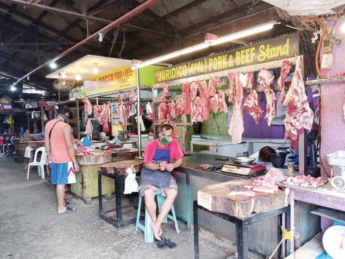 pork-pricey A meat vendor tends his beef and pork stall in the public market of Pavia, Iloilo. Pork prices in the region now hover around P255 per kilo on average compared to last month’s P245. PANAY NEWS PHOTO