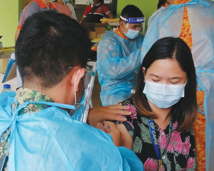 region-glenda-capiz-more-vax An employee of the provincial government of Capiz gets a “vaccine shot” during a vaccination simulation at the Villareal Stadium in Roxas City.