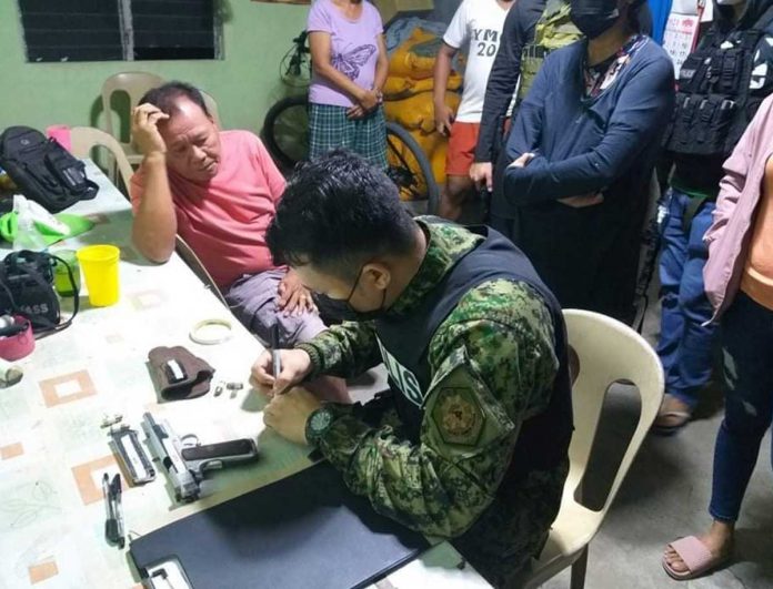 region-stephen-hamtic A police officer is going over the items – a gun and bullets, among others – recovered from the house of the barangay captain of Caromangay in Hamtic, Antique.