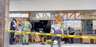 Scene of the Crime Operatives secure the body of a food delivery man who was shot to death by a bank security guard in Barangay Osmeña, Iloilo City.