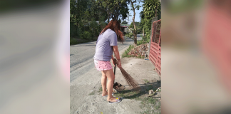 A woman cleans the area in front of her house in Barangay PHHC Block 22, Mandurriao, Iloilo City. Staying home amid the coronavirus pandemic gives people more time to “search and destroy” possible breeding areas of mosquitos, according to the Department of Health. PHOTO BY PAUL ALDRIN MATUNDING