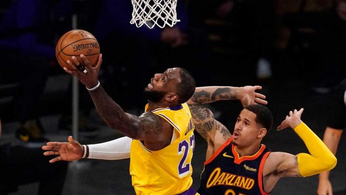 LeBronJames Los Angeles Lakers forward LeBron James (left) shoots past Golden State Warriors forward Juan Toscano-Anderson (right) during the first half of their basketball game in California on Wednesday. MARK TERRILL