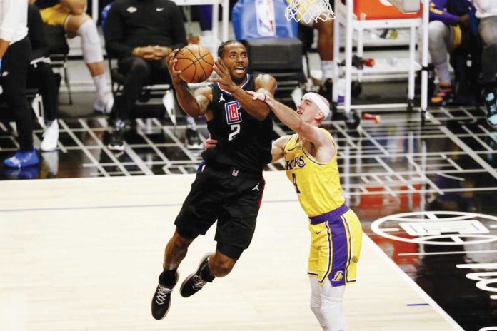 Los Angeles Clippers’ Kawhi Leonard (2) drives to the basket and is fouled by Alex Caruso (4) of Los Angeles Lakers during the second half of their basketball game on Thursday. AP PHOTO/RINGO H.W. CHIU Los Angeles Clippers’ Kawhi Leonard (2) drives to the basket and is fouled by Alex Caruso (4) of Los Angeles Lakers during the second half of their basketball game on Thursday. AP PHOTO/RINGO H.W. CHIU