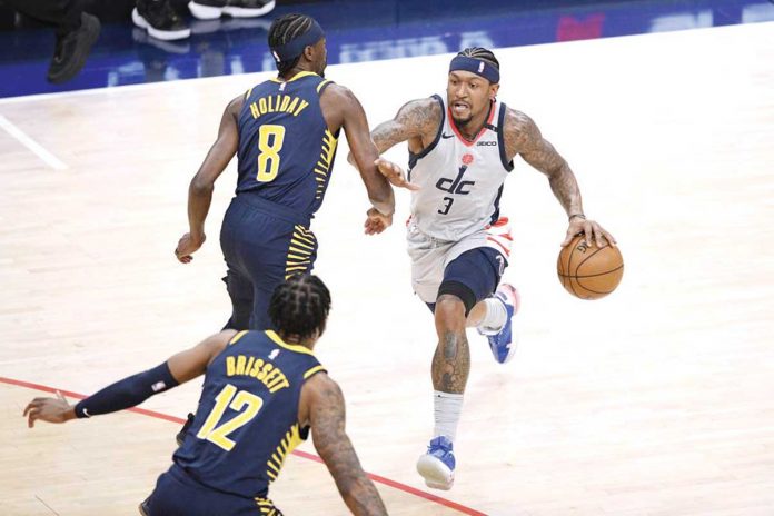 Sports-banner Washington Wizards' Bradley Beal (3) dribbles the ball while Indiana Pacers’ Justin Holiday (8) and Oshae Brissett (12) defend during the first half of their basketball match in the Eastern Conference’s play-in game held in Washington, May 20, 2021. AP PHOTO/NICK WASS