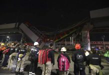 Rescue personnel stand in front of Mexico City subway cars laying at an angle after a section of Line 12 of the subway collapsed in Mexico City on Monday. At least 20 people were killed and 70 were injured. AP PHOTO/MARCO UGARTE
