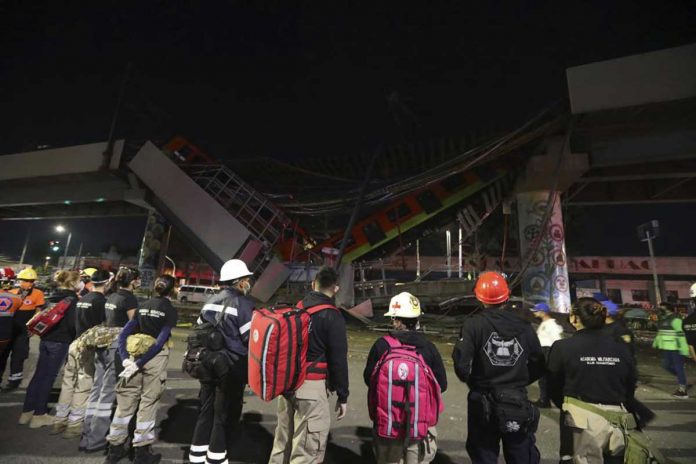 Rescue personnel stand in front of Mexico City subway cars laying at an angle after a section of Line 12 of the subway collapsed in Mexico City on Monday. At least 20 people were killed and 70 were injured. AP PHOTO/MARCO UGARTE