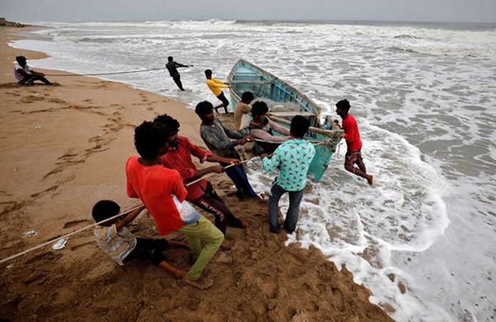 People move a fishing boat to a safer place along the shore ahead of Cyclone Tauktae in Veraval in the western state of Gujarat, India. REUTERS/AMIT DAVE People move a fishing boat to a safer place along the shore ahead of Cyclone Tauktae in Veraval in the western state of Gujarat, India. REUTERS/AMIT DAVE
