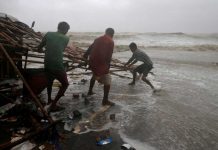 Men remove bamboo rooftop of a stall damaged by heavy winds at a shore ahead of Cyclone Yaas in Bichitrapur in Balasore district in the eastern state of Odisha India. REUTERS/RUPAK DE CHOWDHURI