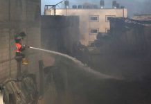 A firefighter puts out a fire at a factory after it was hit by Israeli artillery shells in the northern Gaza Strip on Monday. Israel said the air strikes hit Hamas targets, but homes and other buildings were also damaged. REUTERS/ASHRAF ABU AMRAH
