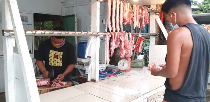 biz-pork-pic A vendor tends to his pork stall in Barangay Balabag, Pavia, Iloilo on May 11, 2021. The country’s chief executive approved an over fourfold increase in the importation of pork to augment the shortage of supply due to the African swine fever. JAPHET FAJARDO/PN