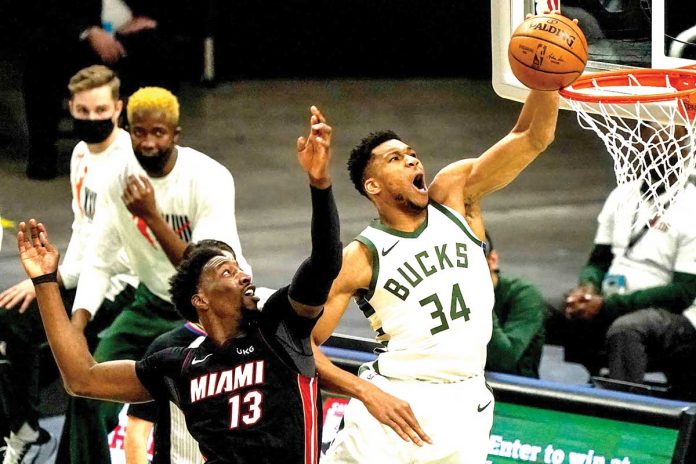 buccks-shut-down-heat Giannis Antetokounmpo (34) shoots past Miami Heat’s defender Bam Adebayo (13) to score for Milwaukee Bucks during Game 3 of NBA’s Eastern Conference first-round playoffs on Thursday at the American Airlines Arena in Florida. MORRY GASH/AP