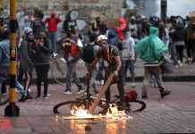 A protester stokes a fire during a protest against the tax reform of President Ivan Duque's government in Bogota, Colombia on May 1, 2021. REUTERS/LUISA GONZALEZ
