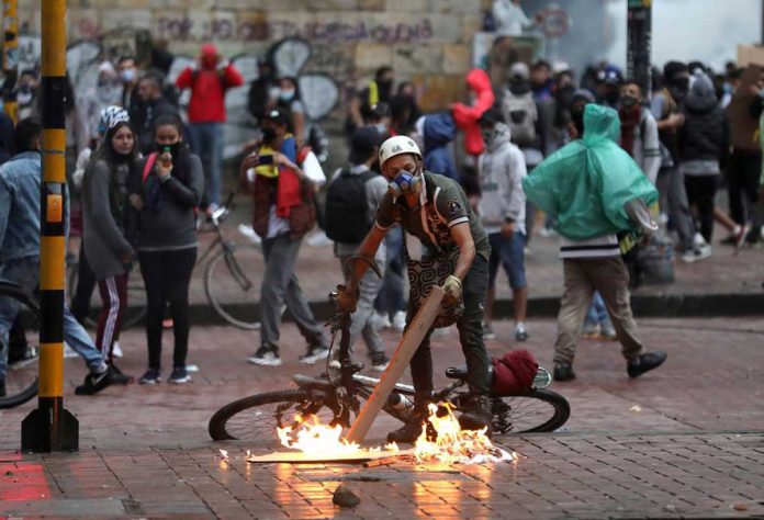 colombia A protester stokes a fire during a protest against the tax reform of President Ivan Duque's government in Bogota, Colombia on May 1, 2021. REUTERS/LUISA GONZALEZ