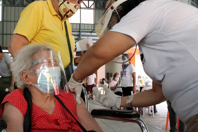 confidence ELDERLY VACCINATED. An elderly woman closes her eyes while getting a jab from a medical health worker at the Eulogio “Amang” Rodriguez Institute of Science and Technology in Manila on Friday. More Filipinos are expected to be vaccinated with the arrival of more COVID-19 vaccine supplies in the coming months. PNA