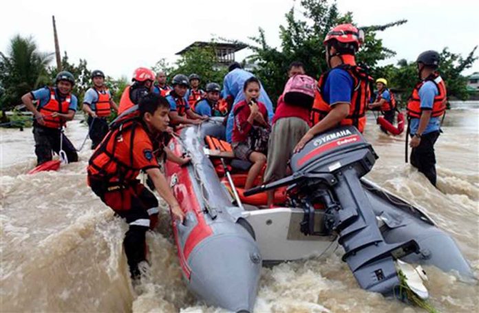 duterte-orders-harmonized-aid Rescuers from the Comval Emergency Response Team evacuate residents who were trapped in the flooding of Compostela Valley and nearby provinces in the southern Philippines. AP FILE PHOTO