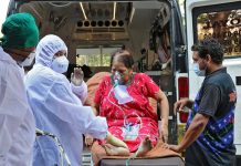 Healthcare workers carry a woman from an ambulance for treatment at a COVID-19 care facility amid the spread of COVID-19 in Mumbai, India. REUTERS/NIHARIKA KULKARNI