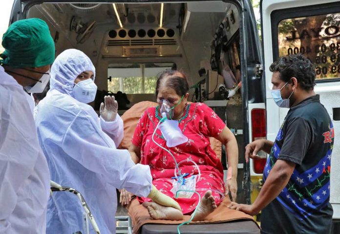 Healthcare workers carry a woman from an ambulance for treatment at a COVID-19 care facility amid the spread of COVID-19 in Mumbai, India. REUTERS/NIHARIKA KULKARNI
