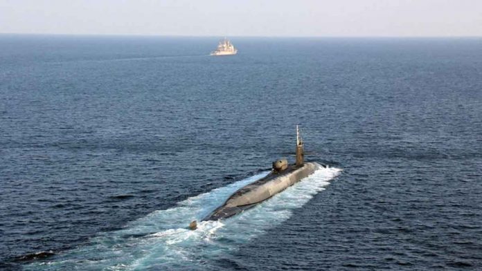 US Navy vessels are escorting USS Georgia, a guided-missile submarine, as it transits the Strait of Hormuz. US NAVY PHOTO