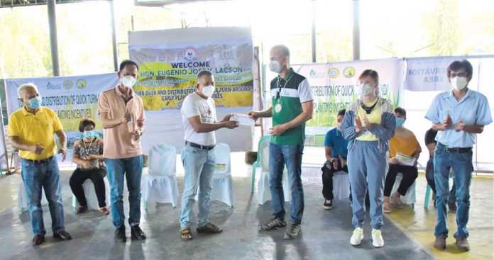 negocc-farmers Negros Occidental’s Governor Eugenio Jose Lacson (right) turns over an early planting incentive to a rice farmer in Hinigaran in the presence of Mayor Nadie Arceo (left) at the municipal gym on Tuesday. PIO NEGROS OCCIDENTAL/FACEBOOK