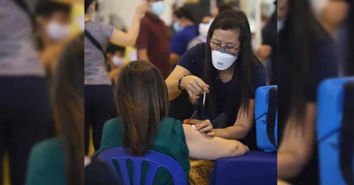 A healthcare worker administers the coronavirus disease 2019 jab to a woman at the Central Philippine University in Iloilo City on Wednesday. To speed up the vaccination rollout, DOH says recipients will not be informed of what brand of vaccine they will receive. JERRY TREÑAS/FACEBOOK