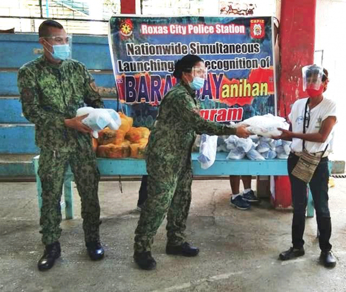 region-glenda-roxas-barangayanihan A beneficiary receives a food pack from the police station of Roxas City. Photo grabbed from Roxas City PCR FB Page