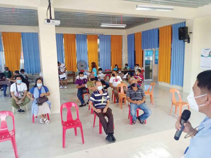 reyes Mayor Eugenio Reyes of Buenavista, Guimaras and Dr. Grace Cortez, municipal health officer, discuss with barangay captains new health protocols. Photo from Buenavista LGU