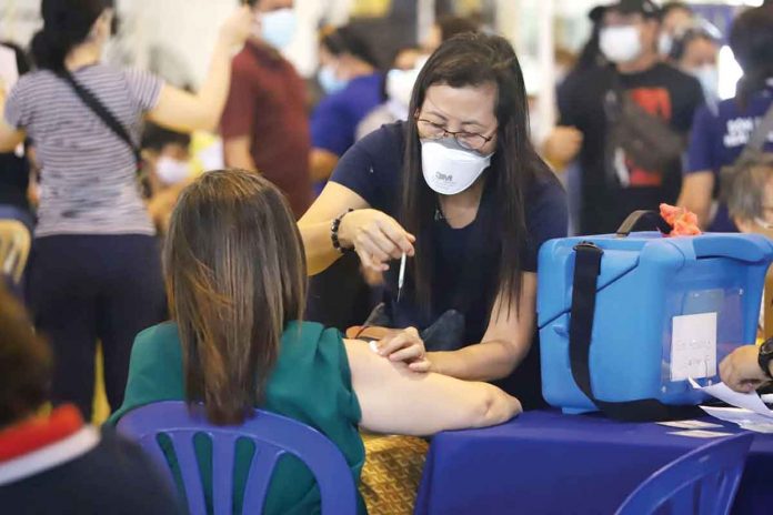 vaccination A healthcare worker administers an anti-coronavirus jab to a vaccinee at Central Philippine University’s gymnasium in Jaro, Iloilo City. The Department of Health has proposed a “brand agnostic” policy wherein the public will only know the vaccine brand they will receive upon arrival at the vaccination site. ARNOLD ALMACEN/CMO