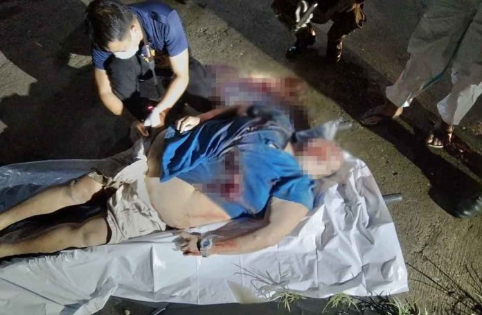 bac-pic Police secure the body of a man shot to death in Barangay Estefania, Bacolod City on Wednesday night. POLICE STATION 4/BCPO