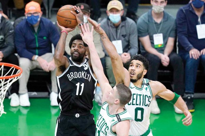 brooklyn-atlanta Brooklyn Nets guard Kyrie Irving (11) drives for a basket against the defense of Boston Celtics' Payton Pritchard (front) and Jayson Tatum (0) during their NBA basketball game on Sunday. AP