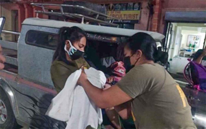 LAUDED. Corporal Mary Joy Fusin, a registered nurse, and Staff Sergeant Maybelle Legario help a mother successfully give birth in Dumalag, Capiz in this undated photo. PHOTO COURTESY OF PNP PIO