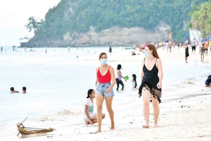 travel Wearing facemasks, tourists walk barefoot on the white sand of Boracay Beach. Since Aklan is under the modified general quarantine until June 30, leisure travel from the NCR Plus to this province is allowed. MALAY TOURISM OFFICE