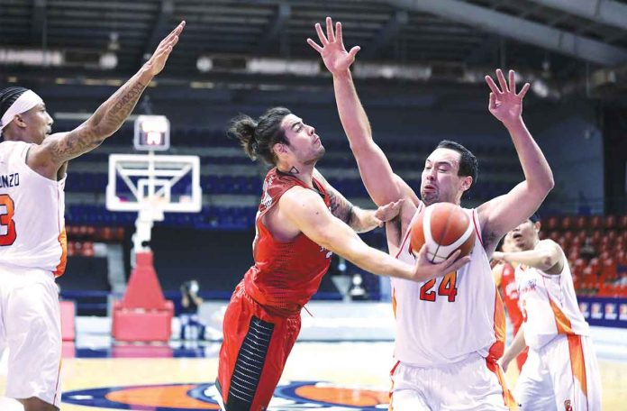 S-2 Barangay Ginebra San Miguel Kings’ Christian Standhardinger (red) tries to escape the defense of NorthPort Batang Pier’s Gregory Slaughter (24) as he goes for an inside basket during the PBA Cup Match on Friday at the Ynares Sports Arena in Pasig City. PBA MEDIA BUREAU