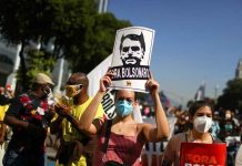 Brazilians protest against prexy over pandemic handling A protester holds a sign reading "Bolsonaro out" during a protest in Rio de Janeiro, Brazil. REUTERS