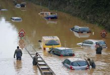 Members of the Bundeswehr forces, surrounded by partially submerged cars, wade through the floodwater following heavy rainfalls in Erftstadt-Blessem, Germany, on Saturday. REUTERS/THILO SCHMUELGEN