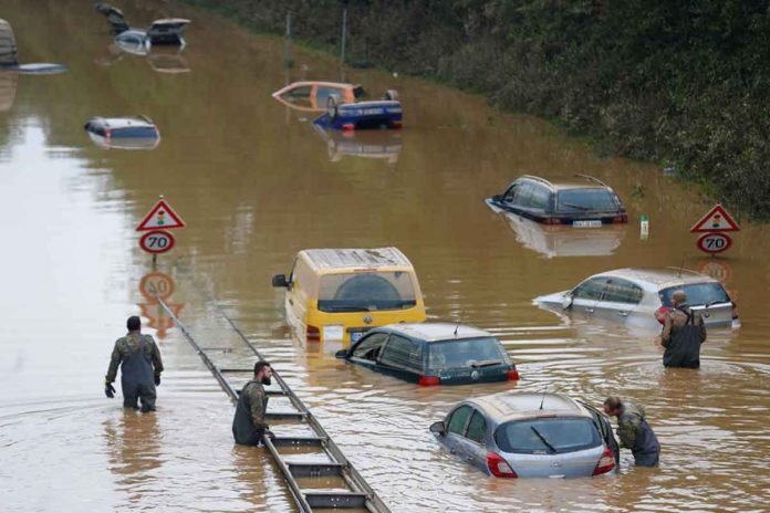 Members of the Bundeswehr forces, surrounded by partially submerged cars, wade through the floodwater following heavy rainfalls in Erftstadt-Blessem, Germany, on Saturday. REUTERS/THILO SCHMUELGEN