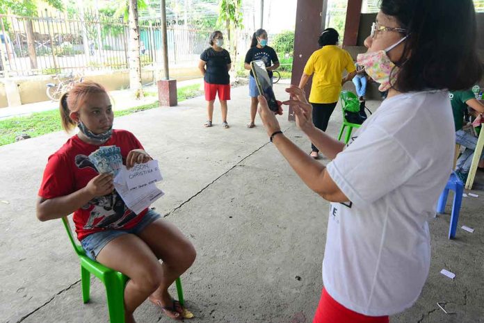 banner A Social Amelioration Program beneficiary in Barangay Lopez Jaena Norte in La Paz, Iloilo City, poses for a picture after receiving P6,000 on July 26, 2020. PANAY NEWS PHOTO