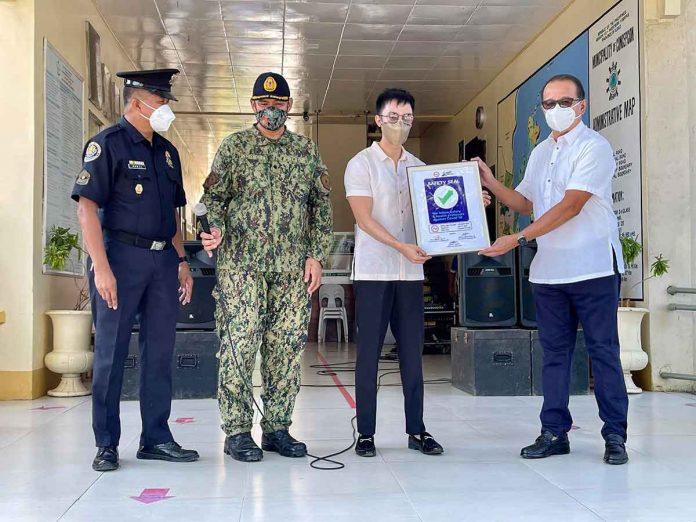 concepcion-safety-seal Concepcion, Iloilo’s Mayor Raul Banias (rightmost) receives a Safety Seal Award from local government operations officer Janwen Gaspar (second from right) on Monday. Joining them were Concepcion police station chief, Police Major Ronnie Brillo (second from left) and acting Fire Marshall Senior Fire Officer 4 Eulogio Poral Jr. MAYOR RAUL BANIAS/FB