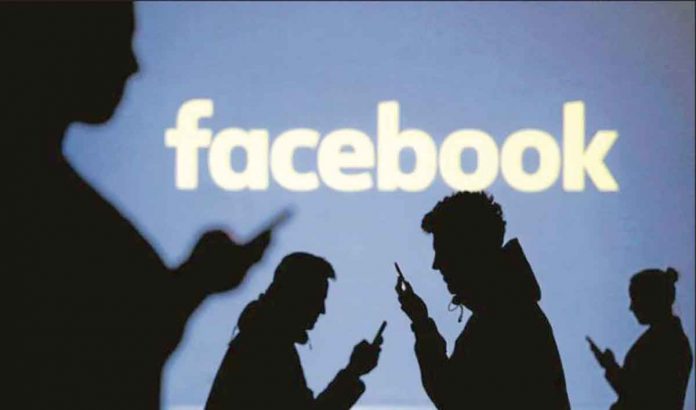 facebook Silhouettes of mobile users are seen next to a screen projection of the Facebook logo in this picture illustration. REUTERS/DADO RUVIC