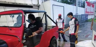 Wearing facemask, a gasoline boy refills the fuel tank of a vehicle in a gasoline station in Pavia, Iloilo. PANAY NEWS PHOTO