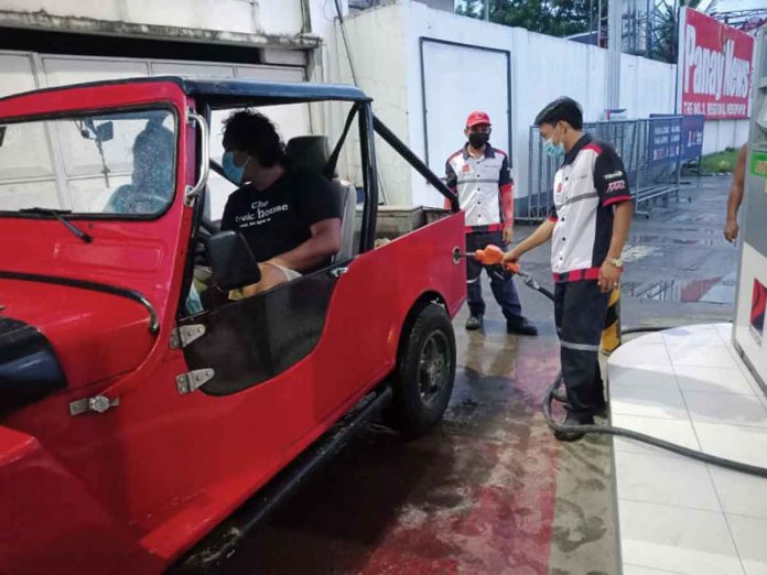 gasoline-price Wearing facemask, a gasoline boy refills the fuel tank of a vehicle in a gasoline station in Pavia, Iloilo. PANAY NEWS PHOTO