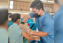 A healthcare worker gives a resident of Iloilo City a vaccine against coronavirus disease 2019 (COVID-19) at the gym of Ateneo de Iloilo in Mandurriao district. The school is one of the vaccination sites of the city government. JAPHET FAJARDO/PN
