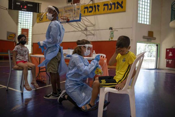 In this file photo, medical personnel test Israeli children for COVID-19 at a testing center in Binyamina, Israel. The country is set to receive a fresh batch of COVID jabs in August. AP PHOTO/ARIEL SCHALIT