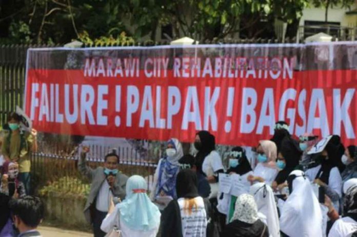 marawi Maranao activists and groups of internally displaced persons display a tarpaulin banner announcing their verdict on how the Duterte administration fared in its promise of making Marawi rise again from the ashes of a five-month war in 2017 against Islamic State terrorists. RYAN D. ROSAURO VIA INQUIRER