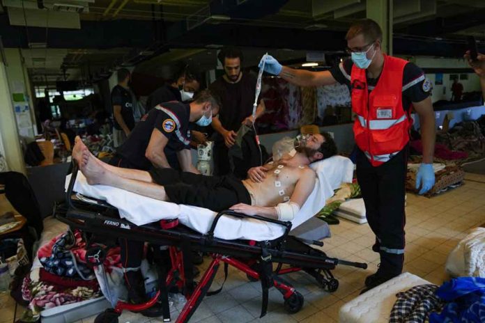 migrant-hunger-strike Firefighters and Red Cross health workers attend a man on hunger strike to be transferred to a hospital as he occupies with others a big room of the ULB Francophone University in Brussels, Belgium. AP/FRANCISCO SECO