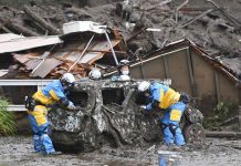 Japan’s leader pushes rescue after deadly mudslide hits town Rescuers check a damaged vehicle at the site of a mudslide in Atami, Shizuoka prefecture. A gush of mud swept away homes and cars in the resort town on Saturday. KYODO NEWS VIA AP
