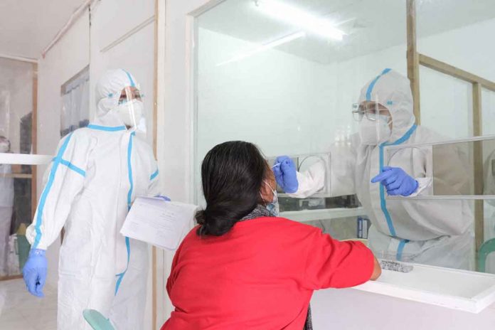 A health worker in Ilocos Norte extracts a swab sample from a resident amid the rising COVID-19 cases there. ILOCOS NORTE PROVINCIAL GOVERNMENT