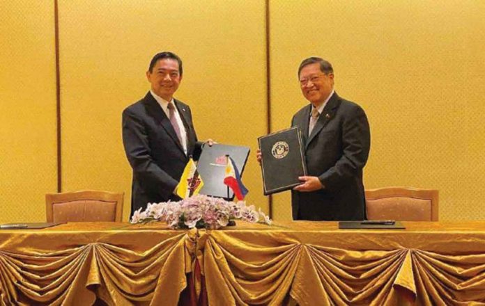ph-brunei Department of Finance secretary Carlos Dominguez (right) of the Philippines and Yang Berhormat Dato Seri Setia Dr. Awang Haji Mohd Amin Liew bin Abdullah (left), minister at the Prime Minister’s Office and Minister of Finance and Economy II of Brunei Darussalam, hold their copies of the double taxation agreement. VIA ABS-CBN NEWS