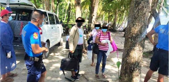 Policemen escort these Boracay Island tourists who presented fake reverse transcription – polymerase chain reaction test results. From their hotel, the tourists were moved to the quarantine facility in Kalibo, Aklan. PRO-6 PHOTO