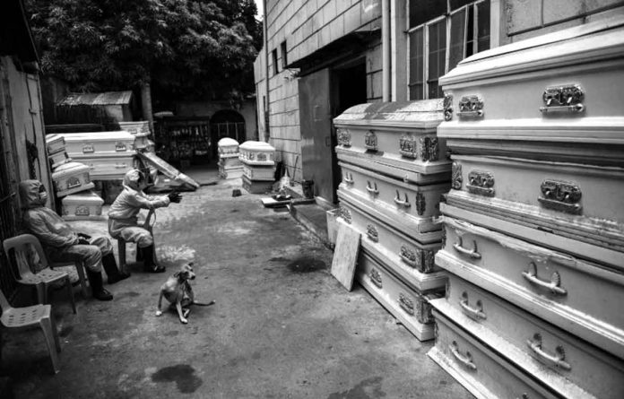 vaccines Workers in protective suits, used due to the COVID-19 coronavirus outbreak, wait outside a crematorium facility in Manila. MARIA TAN/AFP VIA INQUIRER